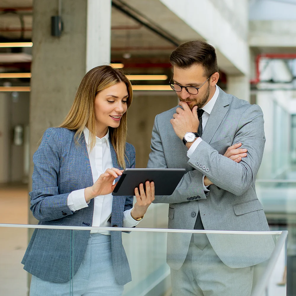 Zwei Fachkräfte im Business-Outfit analysieren gemeinsam Inhalte auf einem Tablet – steht für typische Beratungsszenarien im SAP-Umfeld