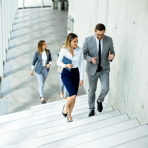 Business-Team steigt gemeinsam eine moderne Treppe hinauf, symbolisiert Fortschritt und Zusammenarbeit