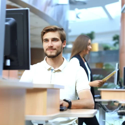 Junger Programmierer arbeitet konzentriert an einem Bildschirm in einem modernen Büro
